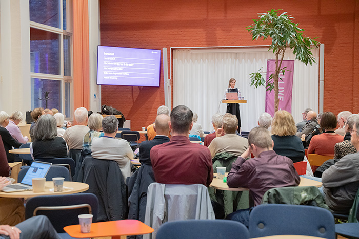 Audience from behind with Malin Stensson on stage.