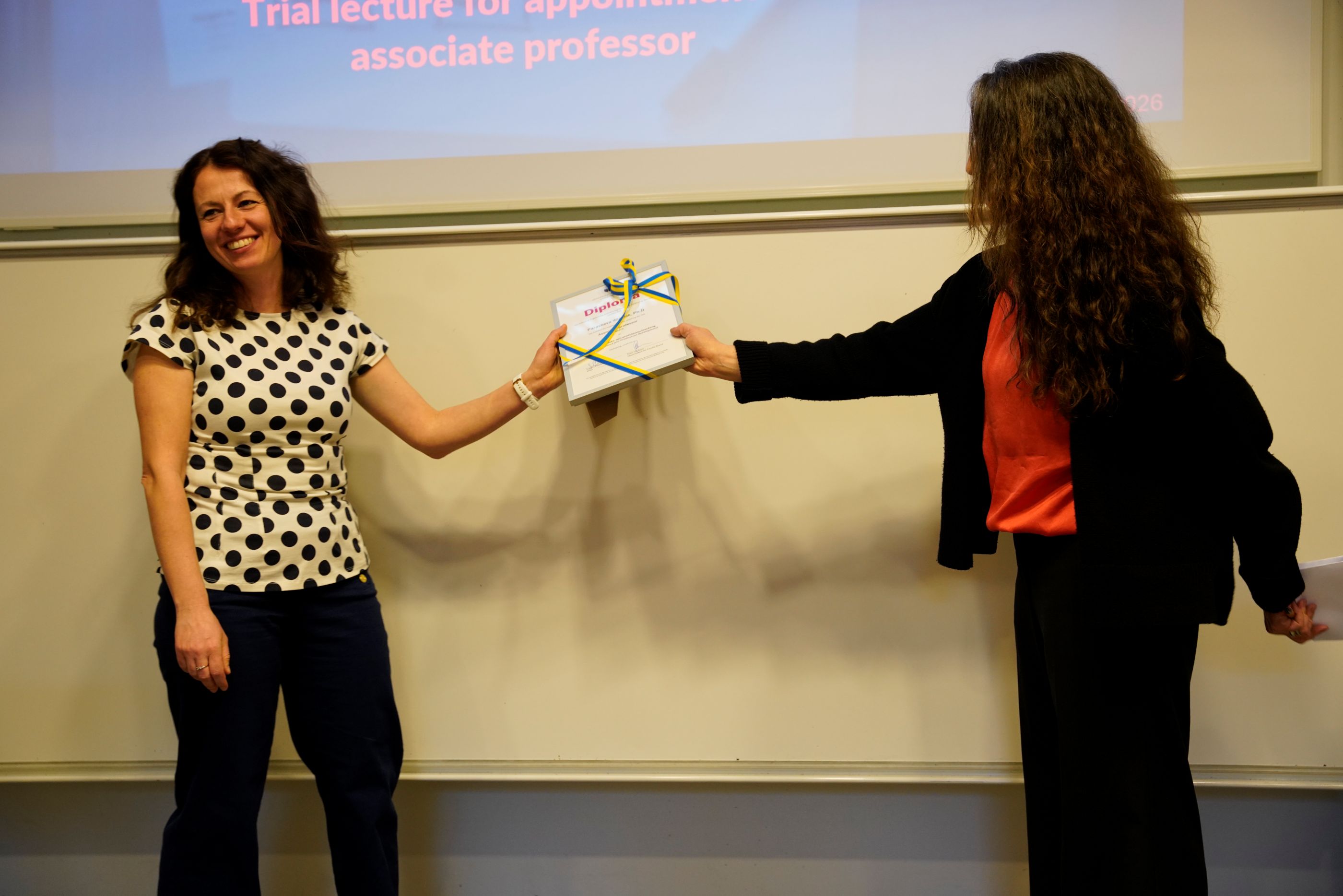 Glad kvinna tar emot diplom..