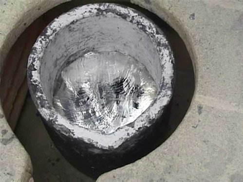 Close up of melted aluminium slurry in a casting bowl.